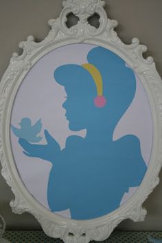 a white frame with a blue silhouette of a woman holding a bird in her hand