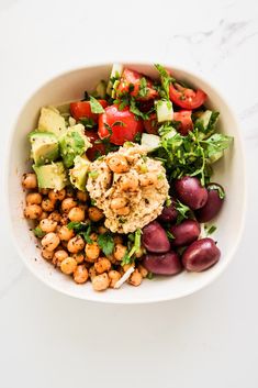 a white bowl filled with vegetables and chickpeas