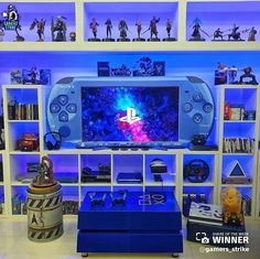 a video game console sitting on top of a table next to a shelf filled with figurines