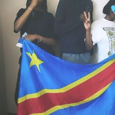 three people standing next to each other holding a flag