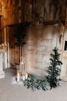 Large frosted glass welcome wedding sign with gold font and candles in glass holders with fur tree and pinecone decor Groom And Groomsmen Outfits, Fairy Lights Wedding, Welcome Wedding Sign, Gold Font, Winter Wedding Decorations, Lights Black, December Wedding, Rock My Wedding