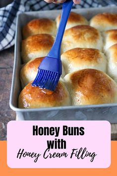 honey buns with honey cream filling in a baking pan being held by a blue spatula