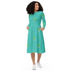 a woman wearing a green dress with cactus print on the sleeves and bottom, standing in front of a white background