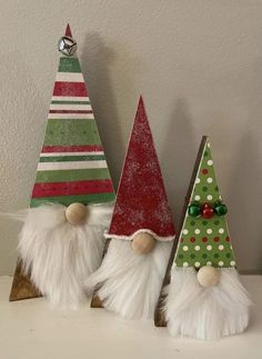 three small christmas trees with white and red hats