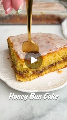 a piece of cake on a white plate with a gold fork sticking out of it