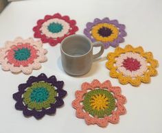 there are crocheted coasters on the table with a coffee cup in it