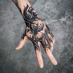 a person's hand with black ink on it and an intricate design in the middle