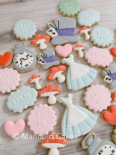 decorated cookies are arranged on a table with the words eat me, eat me written in them