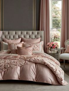 a bed with pink comforters and pillows in a room