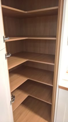 an empty closet with wooden shelves and drawers