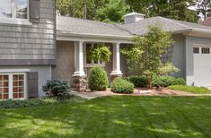 a house with landscaping in front of it and grass around the yard area on both sides