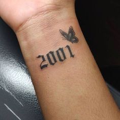 a person with a small tattoo on their wrist that reads 1001 and has a butterfly