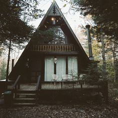 a house in the woods with stairs leading up to it's front door and porch