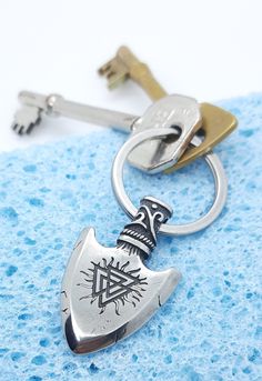 Viking arrowhead Keychain with valknut (Odins triangle) on one side and  vegvisir (viking compass) on other. Premium quality, flat, split ring, 30mm across and 2mm x 2.5mm in thickness. Pendant 42mm x 26mm. Great keychain, bag charm or fashion accessory.   We only use premium 316L stainless steel in our jewellery (we never use cheap alloy substitutes). Stainless steel is is a great choice for jewellery. It is durable, tarnish and scratch resistant, waterproof, hypoallergenic (more so than silver), shiny and affordable.    All our products come gift wrapped in  jewellery pouch and tissue paper at no extra charge.   We aim to dispatch same day where possible. UK  domestic shipping times usually just 2-3 business days. Please be patient with international shipping times which can vary greatly Viking Necklaces, Jewellery Pouch, Viking Necklace, Keychain Bag, Split Ring, Matching Necklaces, Jewelry Pouch, Men Necklace, Key Rings