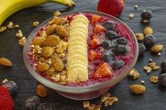 a bowl filled with fruit and nuts next to a banana