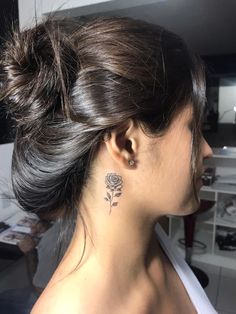 a woman with a rose tattoo on her left side of her neck and behind her ear