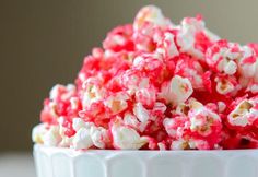 a white bowl filled with red and white popcorn