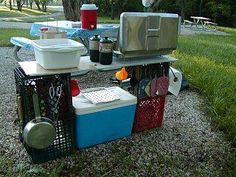 an outdoor picnic table with coolers and food on it