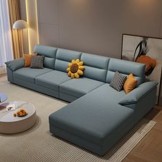 a living room with a large blue couch and sunflower pillows on the back of it