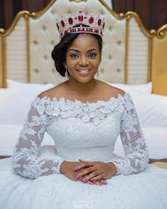 a woman wearing a tiara sitting on a bed