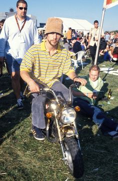 a man riding on the back of a motorcycle next to a small boy sitting in front of him