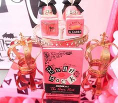 a pink box with three little princess crowns on top and two candles in the middle