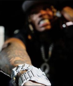 a close up of a person holding something in his hand with chains on it and wearing a hat