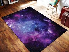 an area rug with purple and blue stars in the center on a wooden floor next to a chair