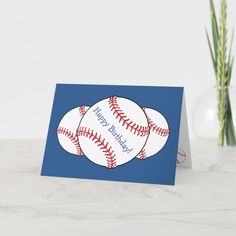 a card with a baseball on it next to a vase filled with yellow flowers and daisies