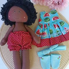 the doll is laying next to her outfit and socks, which are also made out of fabric