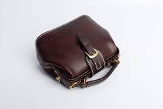 "*DOCTOR BAG'S HANDMADE VIDEO* https://youtu.be/QpdhSCjh2BM Product Description * Material: vegetable tanned leather * Color: Hand-dyeing -Chocolate * Flap over entry with magnetic buckle closure * 0.75\" wide leather shoulder strap adjust from 36.61\" to 44.88\" * Sewn by hand; * Size: 170mm (H) x 180mm (W) x 110mm (D) / 6.7\" x 7.0\" x 4.3\" The Installation of Doctor Bag Frame #Please see the last picture# Doctor Bag Frame is connected by two pairs of screws. Although we will tighten the scre Leather Pouch With Detachable Strap As Gift, Leather Box Bag With Mobile Phone Pouch, Classic Handmade Crossbody Bag, Leather Tote Box Bag With Mobile Phone Bag, Rectangular Leather Lined Pouch For Daily Use, Brown Clutch Box Bag For Everyday Use, Brown Leather Box Bag With Mobile Phone Holder, Brown Leather Mobile Phone Box Bag, Brown Top Handle Pouch For Daily Use