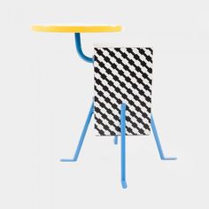 a small table with two blue legs and a black and white checkerboard pattern on it