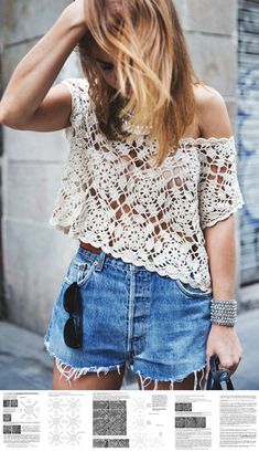 a woman wearing a white crochet top and denim shorts