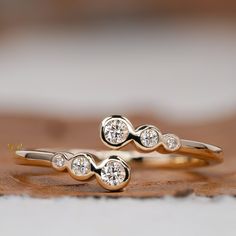 two gold rings with diamonds sitting on top of each other