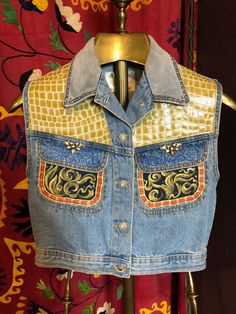 a denim jacket with patches on the front and back, sitting on a mannequin