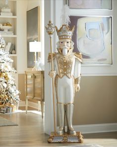 a white and gold statue in front of a christmas tree