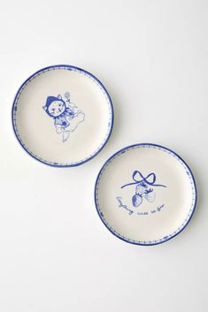 two blue and white plates with cartoon characters on them