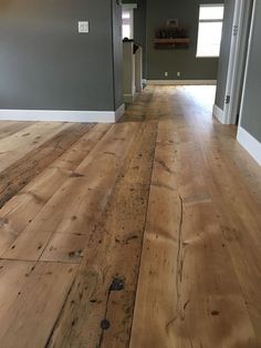 an empty room with wood floors and gray walls