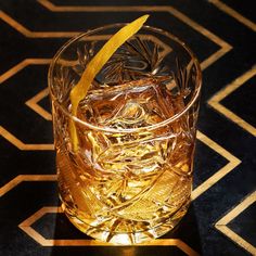 a close up of a glass on a table with a lemon wedge in it's middle