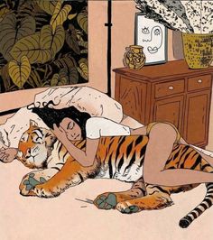 a woman laying on top of a bed next to a tiger