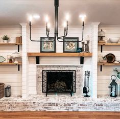 a living room filled with furniture and a fire place under a chandelier above a fireplace