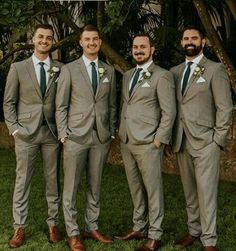 four men in suits and ties are posing for the camera