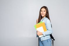 a young woman is holding some folders in her hand and smiling at the camera