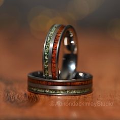 two wedding rings with wood inlays on top of each other