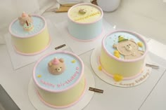 three birthday cakes with teddy bears on them sitting on top of a table next to each other