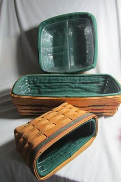 two green and brown baskets sitting next to each other on a white sheeted surface