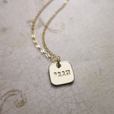 "|ABOUT| ∞This lovely necklace is composed of a 1/2\" 14k gold-filled rounded square pendant stamped with Hebrew for \"Hineni.\"  |DETAILS| ∞Material: 14k gold filled ∞Finish: smooth, polished, imprint only ∞Chain type: 1.5mm delicate cable chain ∞Length: 16\", 18\", 20\" ∞Measurements: 1/2\" diameter ∞Font: Classic Hebrew Block (2.5mm) |ORDERING| ∞Choose your style from the drop-down menu(s), type your personalization (if required by the listing) and then hit \"Add to cart\"!  ∞If needed please 14k Gold Charm Necklace With Square Pendant For Gift, 14k Gold Charm Necklace With Square Pendant, 14k Gold Square Pendant Charm Necklace For Gift, Steel Stamp, Elastic Ribbon, Rounded Square, Choose Your Style, Square Pendant, Ink Stamps