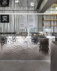 a stainless steel counter in a restaurant with menus hanging on the wall behind it