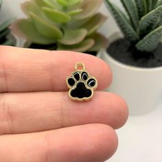 Bring the love of your pup or kitty to every outfit with our Black Enamel and Gold Dog/Cat Paw Print Charms! Each charm is crafted with a gleaming gold finish and enamel accents for a paw-some look. Give your look a touch of pet love with 4, 20, or 50 pieces! -12 x 15 mm-2mm hole-Zinc alloy with enamel fillContains small parts. Not intended for children. Paw Print Charm, Cat Paw Print, Cat Paw, Cat Paws, Gold Enamel, Pet Lover, Cute Packaging, Cat Print, Black Enamel