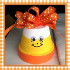 an orange and white paper mache with a bow on top